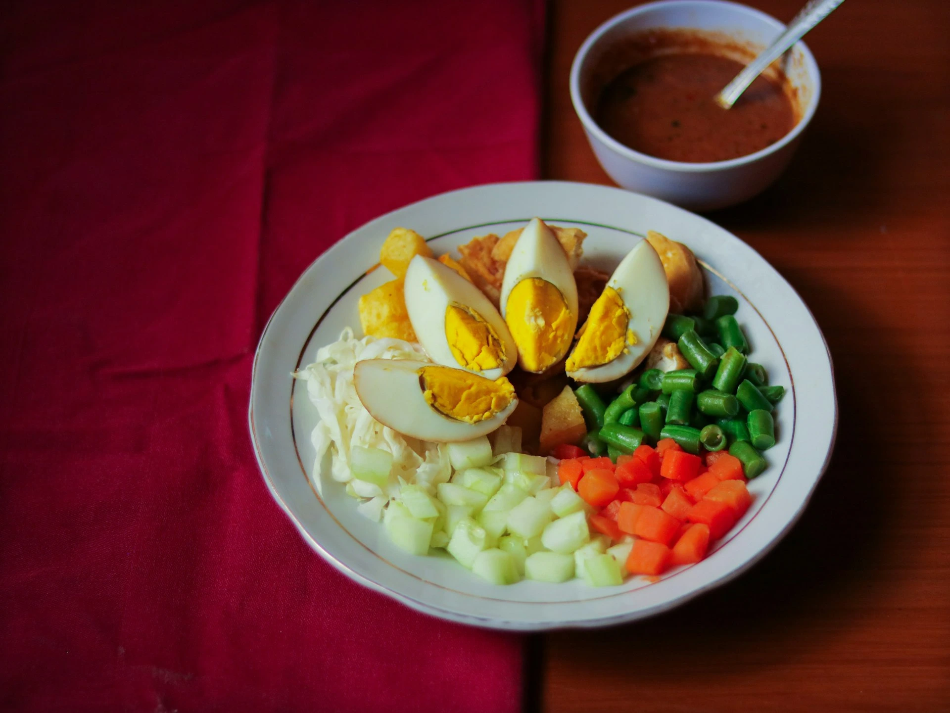 Chopped vegetables and eggs on a white ceramic plate